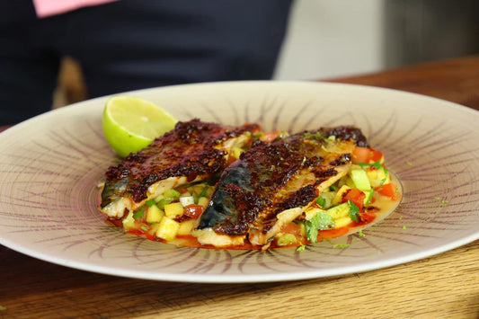 white round plate filled with tropical mango salad and grilled mackerel with RoniB's Kitchen Black Bean Chilli Paste