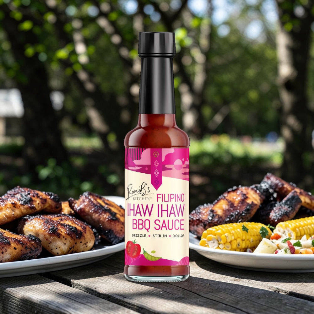 Bottle of Filipino Haw Haw BBQ Sauce on a wooden table with grilled chicken and corn in the background.