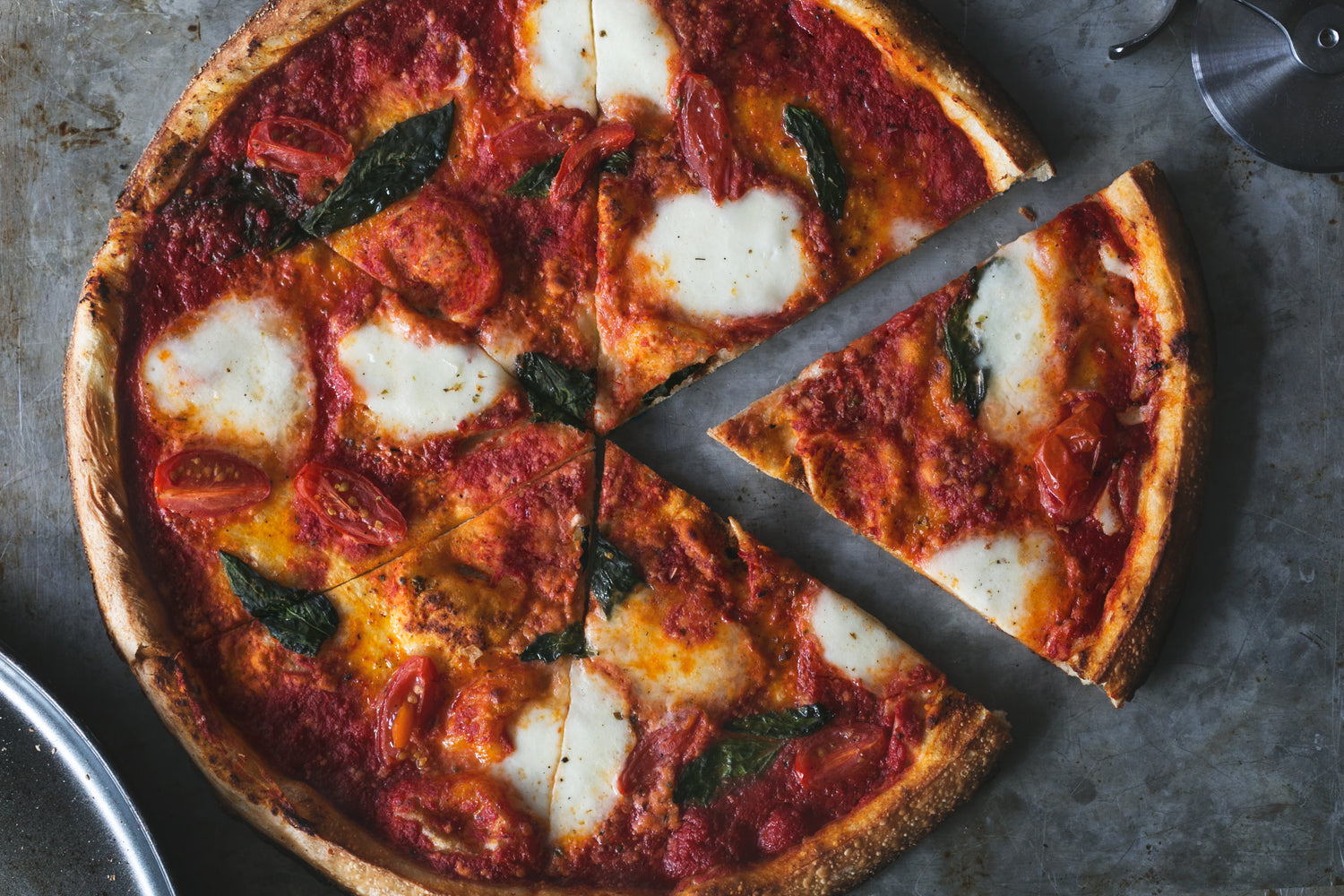 A top view of a pizza with one slice moved from the rest