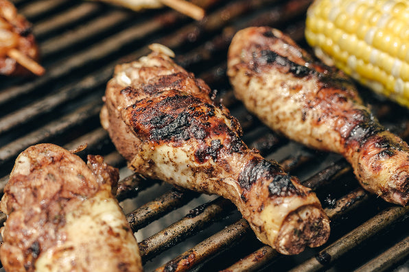chicken drumsticks with corn on a grill
