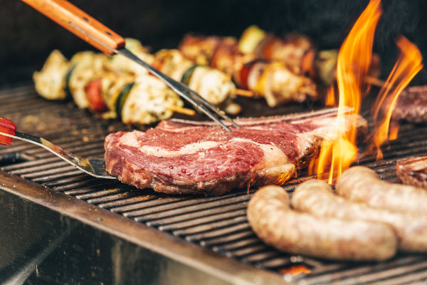 steak and sausages with skewered meat with veggies on a grill